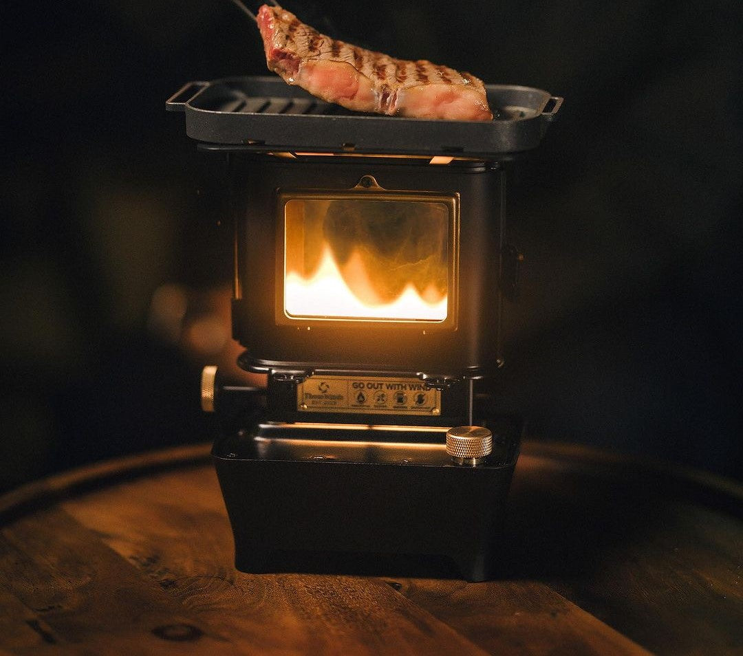 grilling a steak on a vintage black kerosene campstove outdoors on a wooden table ashtagoutdoors